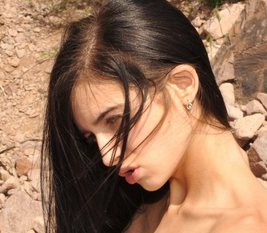 Zoe Rush's shoulder is bare and her long black hair is blowing in the breeze.